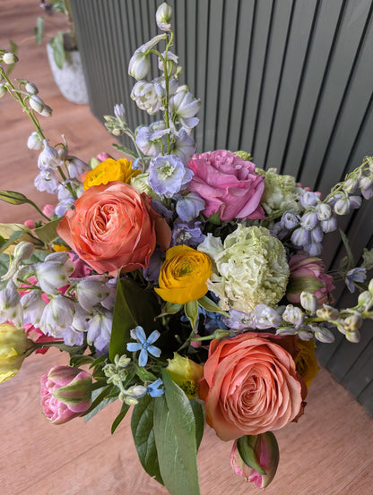 Large colorful garden style floral arrangement roses ranunculus delphinium, tweedia, tulips